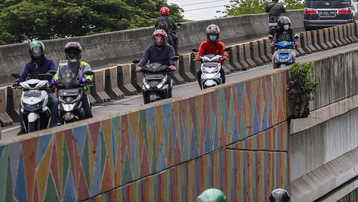 Pengendara motor melintasi flyover Pesing, Jakarta, Minggu (9/1/2022). Meskipun dilarang untuk melintas, para pengendara tetap nekat melewati flyover tersebut. ANTARA FOTO/Rivan Awal Lingga/foc.