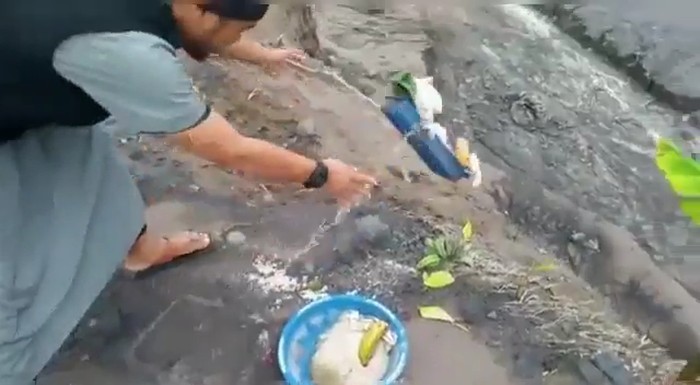 pria buang sesajen di semeru