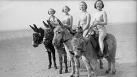 Pada foto yang dipotret tahun 1936 ini terlihat sejumlah wisatawan menunggangi keledai di pantai yang berada di kawasan Blackpool. Fox Photos/Getty Images.