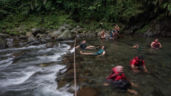 Sejumlah wisatawan bermain air di Wisata Black Canyon, Petungkriyono, Kabupaten Pekalongan, Jawa Tengah, Sabtu (8/1/2022). Wisata air terjun dengan dinding bebatuan alam berwarna hitam yang dikelola oleh kelompok sadar wisata (Pokdarwis) setempat itu menjadi salah satu tujuan liburan favorit di Kabupaten Pekalongan saat akhir pekan. ANTARA FOTO/Harviyan Perdana Putra/rwa.