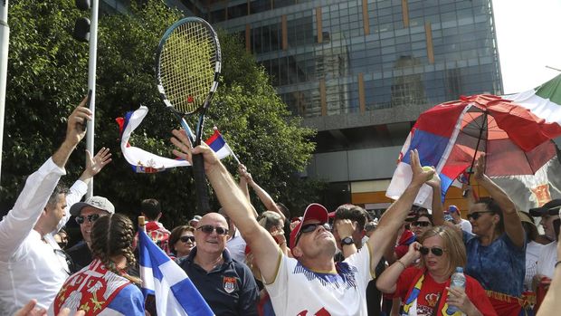 Fans of Serbian tennis star Novak Djokovic react to news of his overturned ruling outside Federal Court ahead of the Australian Open in Melbourne, Australia, Monday, Jan. 10, 2022. An Australian judge has reinstated Djokovic's visa, which was canceled after his arrival last week because he is unvaccinated. (AP Photo/Hamish Blair)