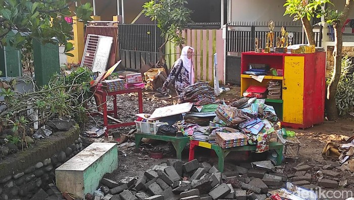 Sekitar 30 KK di RW 13 Perumahan Bumi Mangli Indah (BMI) Kelurahan Mangli, Kecamatan Kaliwates masih terisolasi akibat banjir yang terjadi Minggu (9/1). Mereka sulit keluar rumah karena kondisi jalan utama rusak parah.