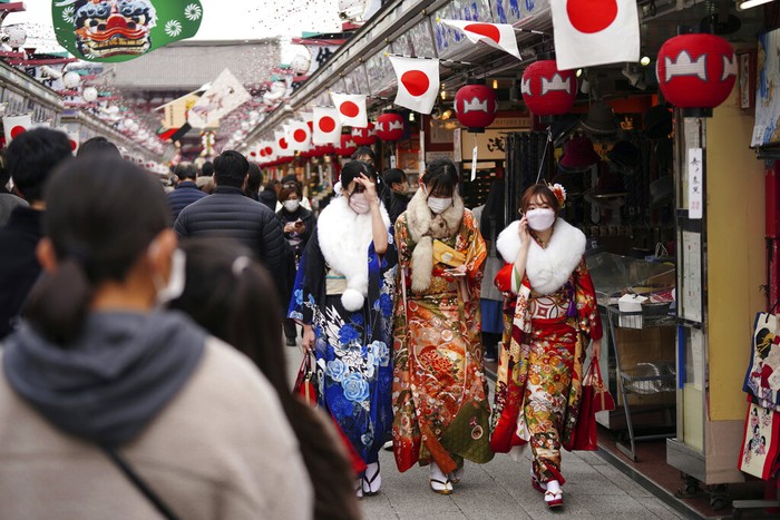 Kimono-clad women celebrating turning 20 years old take selfie together prior to attending a Coming-of-Age ceremony Monday, Jan. 10, 2022, in Tokyo. Held annually on the second Monday of January, Coming of Age Day is a special time for those young adults. (AP Photo/Eugene Hoshiko)