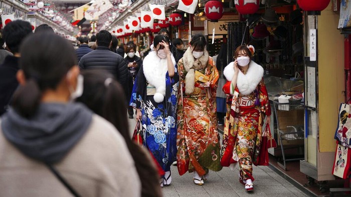 Kimono-clad women celebrating turning 20 years old take selfie together prior to attending a Coming-of-Age ceremony Monday, Jan. 10, 2022, in Tokyo. Held annually on the second Monday of January, Coming of Age Day is a special time for those young adults. (AP Photo/Eugene Hoshiko)