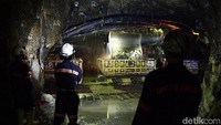 Tiga orang pekerja mengawasi proses penambangan material batu yang mengandung emas di salah satu lorong dengan kedalaman 3 kilomater.