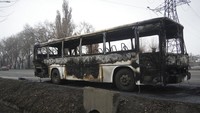 Sebuah bus terbakar dalam bentrokan, terlihat di sebuah jalan di Almaty, Kazakhstan. (AP/Vladimir Tretyakov)
