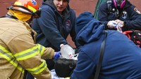 Petugas mengevakuasi salah satu korban kebakaran dahsyat di sebuah bangunan yang ada di kawasan New York, Amerika Serikat, Minggu (9/1/2022) waktu setempat. AP Photo/Lloyd Mitchell.