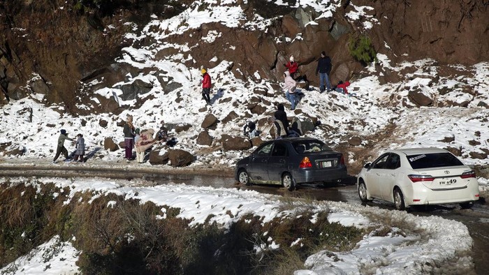 Pakistan Winter Resort Deaths Family members walk on a snow-covered road in a heavy snowfall-hit area in Murree, some 28 miles (45 kilometers) north of the capital of Islamabad, Pakistan, Saturday, Jan. 8, 2022. Temperatures fell to minus 8 degrees Celsius (17.6 Fahrenheit) amid heavy snowfall at Pakistan's mountain resort town of Murree overnight, killing multiple people who were stuck in their vehicles, officials said Saturday. (AP Photo/Rahmat Gul)