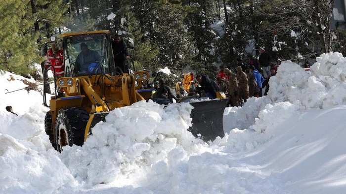 Pakistan Winter Resort Deaths Pakistani workers use a bulldozer to open a road that was blocked by a heavy snowstorm, in Murree some 28 miles (46 kilometers) north of the capital of Islamabad, Pakistan, Sunday, Jan. 9, 2022. Roads at the popular Pakistani resort were cleared Sunday after the deaths of some 22 people who were stuck in their cars during a heavy snowstorm as temperatures plummeted, officials said. (AP Photo/Raja Imran)