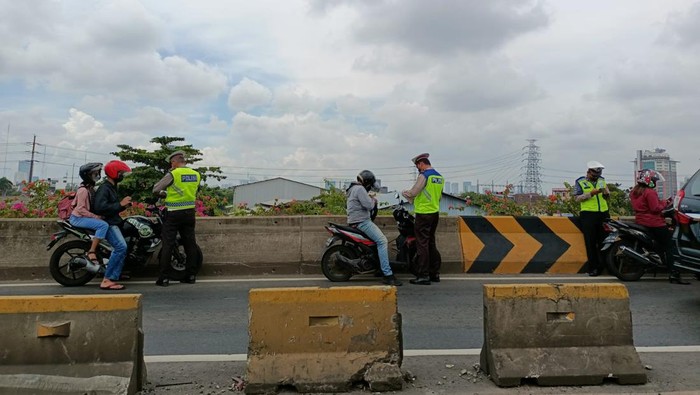 Polisi razia pemotor di flyover Pesing, Jakarta Barat, Senin (9/1/2022).