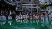 Peserta bersiap untuk mengikuti upacara mandi es selama ritual tahunan Shinto tahun baru di Kuil Teppozu Inari Shinto, Tokyo, Jepang, Minggu, (9/1/2022).