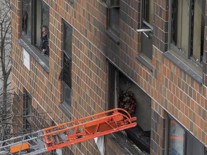 A ladder leads up to a window after a fatal fire at an apartment building in the Bronx on Sunday, Jan. 9, 2022, in New York. The majority of victims were suffering from severe smoke inhalation, FDNY Commissioner Daniel Nigro said. (AP Photo/Yuki Iwamura)