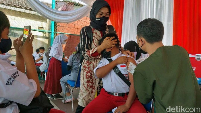 Takut Divaksin, Siswa SD Ini Sembunyi di Balik Kursi Ribuan siswa SD usia 6-11 tahun mengikuti vaksinasi COVID-19 di Mapolres Cimahi. Seorang anak tampak ketakutan dan sembunyi di balik kursi.
