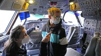 Seorang anak melihat ke dalam ruangan kokpit pesawat Airbus A300 Zero G usai divaksin COVID-19 di pesawat tersebut, Jerman, Minggu (9/1/2022) waktu setempat.