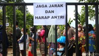 Sejumlah warga menunggu untuk mendapatkan antrean saat operasi pasar minyak goreng murah.