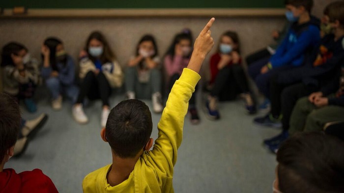 Students of elementary school resume classes after Christmas break in Barcelona, Spain, Monday, Jan. 10, 2022. Some 8 million primary and secondary-level students were resuming classes Monday after a long Christmas and New Year break, although authorities have shortened isolation periods and softened the requirements for quarantining entire classrooms when outbreaks happen to avoid major disruptions in schools. (AP Photo/Emilio Morenatti)