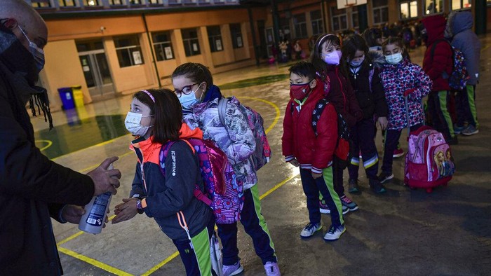 A group of young students wearing face mask protection to prevent the spread of the coronavirus attend their first class in Luis Amigo school after Christmas holidays, in Pamplona, northern Spain, Monday, Jan. 10, 2022. Spanish health authorities try to control high incidence curve of COVID-19.(AP Photo/Alvaro Barrientos)