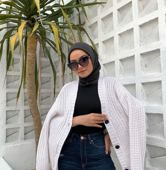Tak hanya menyukai warna earth tone, Diba juga membagikan foto OOTD bernuansa monokrom. Seperti foto OOTD Diba kali ini, ia mengenakan hijab segi empat hitam dengan atasan hitam, celana jeans highwaist dipadu dengan outer rajut bahan knit putih. Foto: Dok. Instagram @dibafahira.