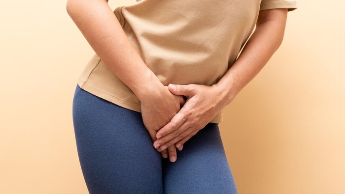 Closeup sick woman with hands holding pressing her crotch isolated on background