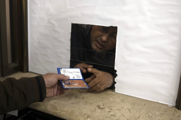 Palestinians wait to receive their official population register letters at the civil affairs office in Gaza City, Monday, Jan. 3, 2022. In recent months, Israel has approved residency for thousands of Palestinians in the occupied West Bank and Gaza, allowing them to get an official Palestinian ID number that grants them the possibility to travel abroad and clear up years of uncertain legal status. (AP Photo/ Khalil Hamra)