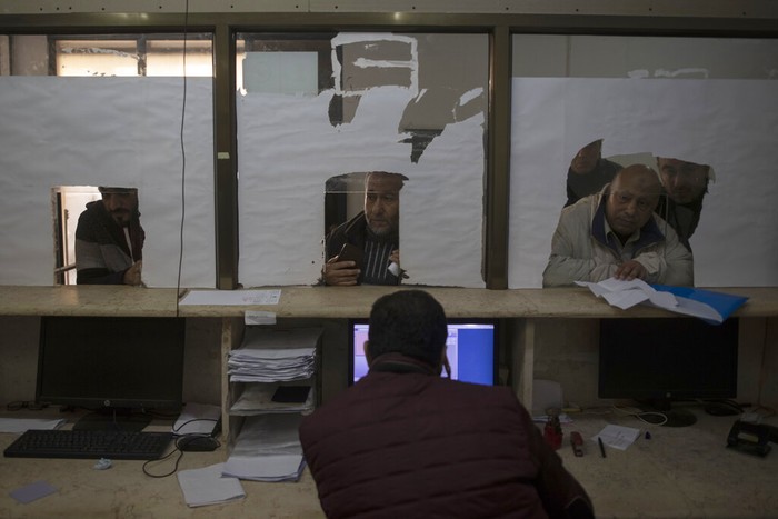 Israel Palestinian IDs Palestinians wait to receive their official population register letters at the civil affairs office in Gaza City, Monday, Jan. 3, 2022. In recent months,Β IsraelΒ has approved residency for thousands of Palestinians in the occupied West Bank and Gaza, allowing them to get an official Palestinian ID number that grants them the possibility to travel abroad and clear up years of uncertain legal status. (AP Photo/ Khalil Hamra)
