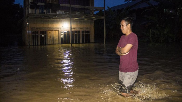 Warga melintasi banjir yang merendam permukiman di Kecamatan Pengaron, Kabupaten Banjar, Kalimantan Selatan, Selasa (11/1/2022). Hujan dengan intensitas sedang hingga lebat menyebabkan air Sungai Pengaron meluap dan membanjiri ratusan rumah warga. ANTARA FOTO/Bayu Pratama S/tom.