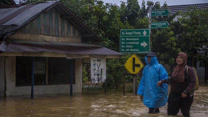 Warga melintasi banjir yang merendam permukiman di Kecamatan Pengaron, Kabupaten Banjar, Kalimantan Selatan, Selasa (11/1/2022). Hujan dengan intensitas sedang hingga lebat menyebabkan air Sungai Pengaron meluap dan membanjiri ratusan rumah warga. ANTARA FOTO/Bayu Pratama S/tom.