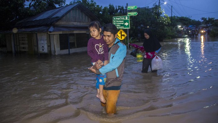 Warga melintasi banjir yang merendam permukiman di Kecamatan Pengaron, Kabupaten Banjar, Kalimantan Selatan, Selasa (11/1/2022). Hujan dengan intensitas sedang hingga lebat menyebabkan air Sungai Pengaron meluap dan membanjiri ratusan rumah warga. ANTARA FOTO/Bayu Pratama S/tom.