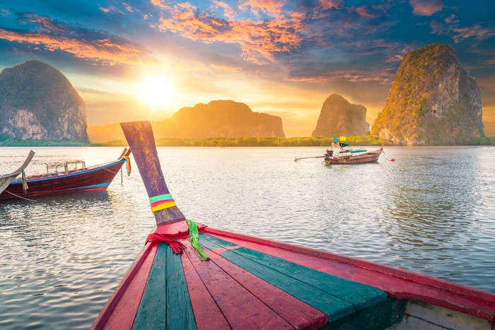 Beautiful sunset at tropical sea with long tail boat in south thailand