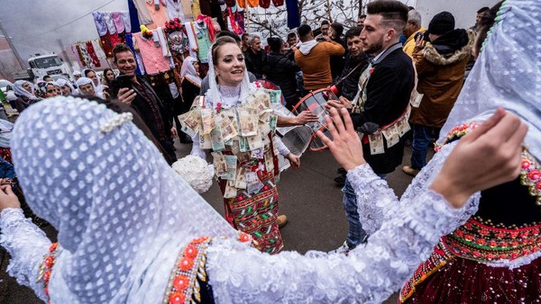 Pengantin Muslim Nefie Eminkova, (kiri) dan pengantin pria Shaban Kiselov, (kanan) menari di jalan, selama hari pernikahan mereka (9/1/2022), di Ribnovo, Bulgaria. Desa Ribnovo yang terletak di pegunungan terpencil di barat daya Bulgaria ini masih tetap mempertahankan tradisi unik mereka. Pengantin Muslim Nefie Eminkova, (kiri) dan pengantin pria Shaban Kiselov, (kanan) menari di jalan, selama hari pernikahan mereka (9/1/2022), di Ribnovo, Bulgaria. Desa Ribnovo yang terletak di pegunungan terpencil di barat daya Bulgaria ini masih tetap mempertahankan tradisi unik mereka.
