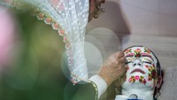 Wanita muslimah merias wajah pengantin wanita Nefie Eminkova pada hari pernikahannya.