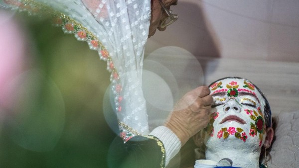 Wanita muslimah merias wajah pengantin wanita Nefie Eminkova pada hari pernikahannya.