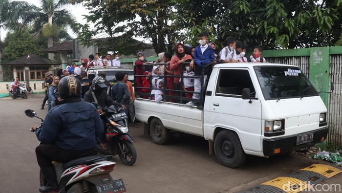 Siswa di Kabupaten Bandung naik mobil bak terbuka ke lokasi vaksinasi COVID-19.