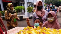 Tidak sedikit warga yang membawa serta anaknya saat antre membeli minyak goreng.