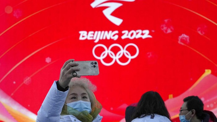 A resident is silhouetted as she exercises with a colored ribbon in Beijing, China, Tuesday, Jan. 11, 2022. The Chinese capital is on high alert ahead of the Winter Olympics as China locks down a third city elsewhere for COVID-19 outbreak. (AP Photo/Ng Han Guan)