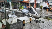 Selain baliho, ada tiang listrik yang juga ambruk dan hampir mengenai apotek di sebelahnya.