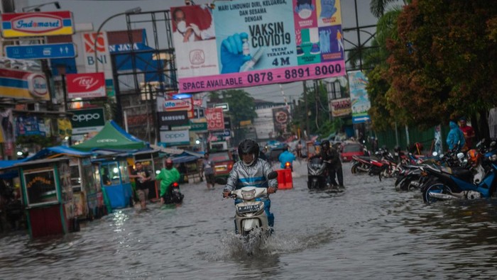 Warga berjalan menerobos banjir di Rangkasbitung, Lebak, Banten, Rabu (12/1/2022). Curah hujan tinggi di daerah tersebut menyebabkan banjir setinggi 30 hingga 70 sentimeter di beberapa tempat di Kabupaten Lebak. ANTARA FOTO/Muhammad Bagus Khoirunas/foc.