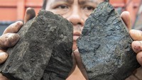 Pekerja menunjukkan batu bara di Pelabuhan PT Karya Citra Nusantara (KCN), Marunda, Jakarta, Rabu (12/1/2022).