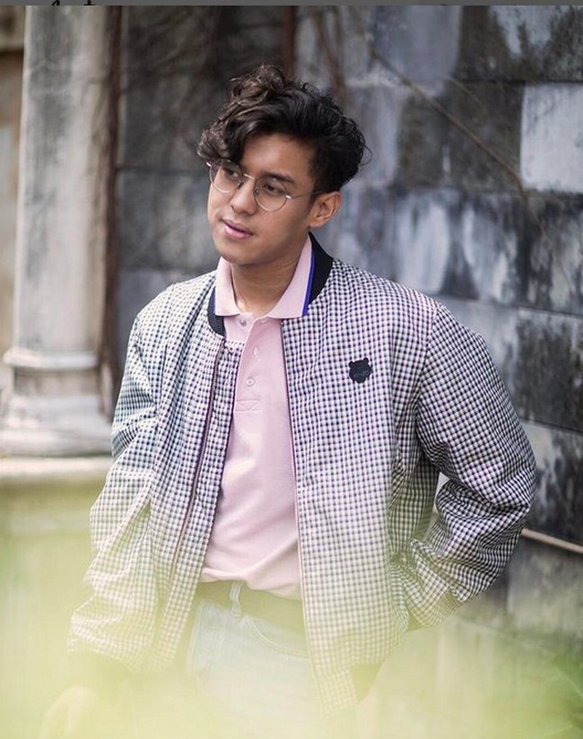 Bomber jacket dengan beragam versi kerap menjadi andalan Ardhito Pramono. Pernah ia difoto sambil bergaya dengan bomber motif plaid sebagai luaran polo shirt pink. (Foto: Instagram/@ardhitopramono)