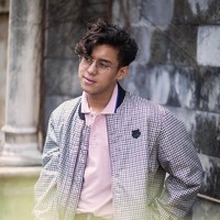 Bomber jacket dengan beragam versi kerap menjadi andalan Ardhito Pramono. Pernah ia difoto sambil bergaya dengan bomber motif plaid sebagai luaran polo shirt pink. (Foto: Instagram/@ardhitopramono)