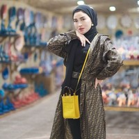 Sebagai pengusaha sukses, barang branded selalu melekat pada gayanya sehari-hari. Seperti kali ini, Shandy Purnamasari memakai brown silk dress dari Fendi seharga Rp 38 juta dan mini shunshine shopper Fendi seharga Rp 25 juta. Ia menjadikan dress sebagai outer dan memadukannya dengan hijab pashmina dan dalaman warna hitam. Foto: Dok. Instagram @shandypurnamasari.
