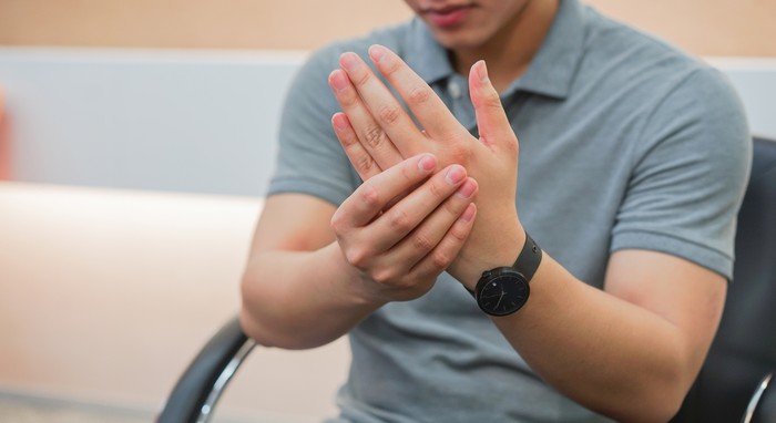 close up employee man massage on his hand and arm for relief pain from hard working ,carpal tunnel syndrome concept