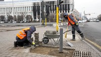 Pekerja kota memperbaiki trotoar di gedung balai kota di alun-alun pusat di Almaty, Kazakhstan. Presiden Kazakhstan mengumumkan bahwa aliansi keamanan yang dipimpin Rusia akan mulai menarik pasukannya dari negara itu setelah menyelesaikan misinya. (AP Photo)