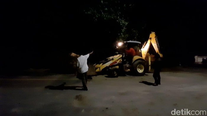 Proses evakuasi batu besar yang tutupi sebagian Jalan Cadas Pangeran.