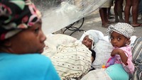 Korban selamat terlihat di tenda pengungsian yang berada di Ibu Kota Port Au Prince, Haiti, (14/1/2010). Joe Raedle/Getty Images.