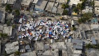 Tenda pengungsian didirikan di tanah lapang, di antara permukiman penduduk yang hancur akibat gempa, (13/1/2010). Logan Abassi/MINUSTAH via Getty Images.