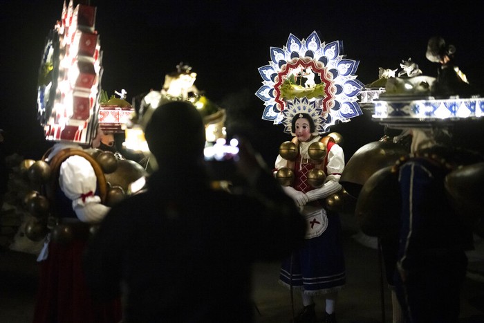 A so-called 'Silvesterchlaus' (New Years Claus) of the group 'Hoernli-Schuppel' is on the way in Hundwil, Switzerland, Thursday, January 13, 2022 to offer best wishes for the New Year (following the Julian calendar) to the farmers in this region. After their performance of singing and dancing the Silvesterchlaeuse receive hot drinks. (Gian Ehrenzeller/Keystone via AP)