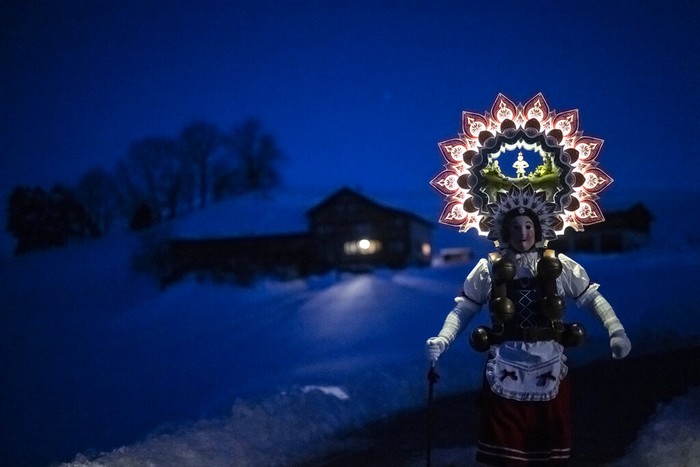 APTOPIX Switzerland Daily Life A so-called 'Silvesterchlaus' (New Years Claus) of the group 'Hoernli-Schuppel' is on the way in Hundwil, Switzerland, Thursday, January 13, 2022 to offer best wishes for the New Year (following the Julian calendar) to the farmers in this region. After their performance of singing and dancing the Silvesterchlaeuse receive hot drinks. (Gian Ehrenzeller/Keystone via AP)