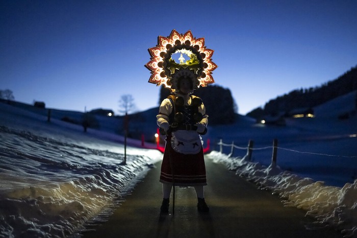 APTOPIX Switzerland Daily Life A so-called 'Silvesterchlaus' (New Years Claus) of the group 'Hoernli-Schuppel' is on the way in Hundwil, Switzerland, Thursday, January 13, 2022 to offer best wishes for the New Year (following the Julian calendar) to the farmers in this region. After their performance of singing and dancing the Silvesterchlaeuse receive hot drinks. (Gian Ehrenzeller/Keystone via AP)