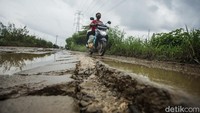 Tak hanya berlubang, jalan ini juga dipenuhi lumpur yang licin.